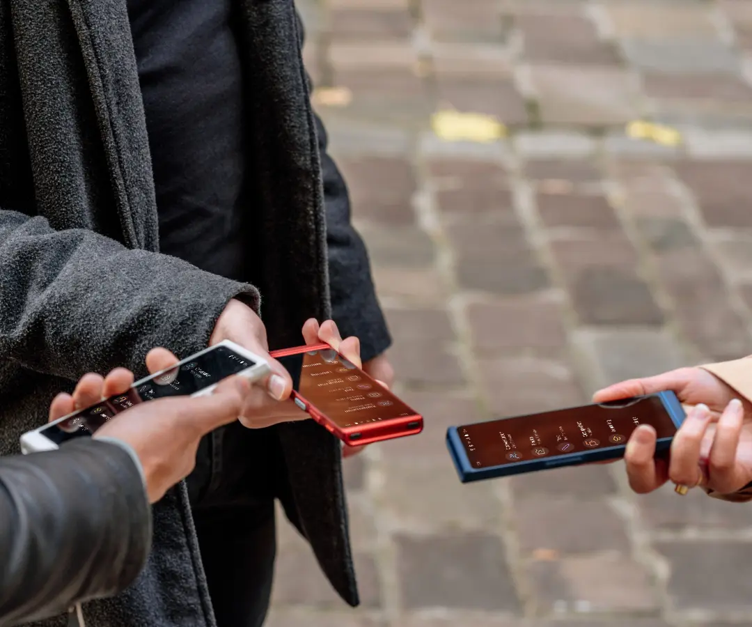 Drei Freunde, die glücklich ihre Übersetzer halten und sich unterhalten.