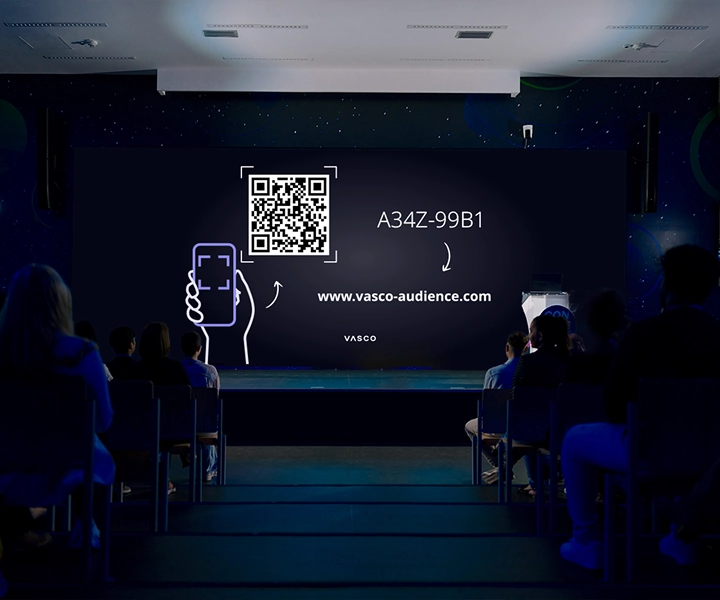 Auf einem großen Bildschirm im Konferenzraum werden die Anweisungen „Join Vasco Audience“ angezeigt, die den Teilnehmern zeigen, wie sie auf die Sitzung zugreifen können.
