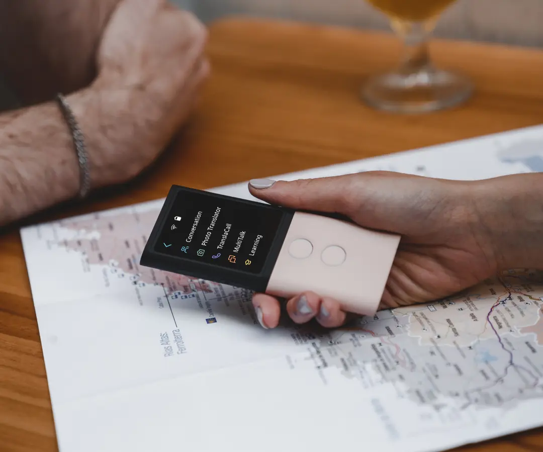 Nahaufnahme einer Hand, die einen Übersetzer über einen Tisch mit einer Karte hält